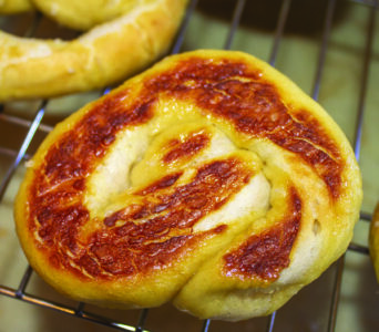 Closeup of the bottom of a homemade soft pretzel on a metal dryi